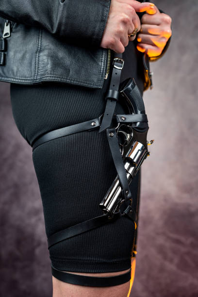 istock killer in black clothes with black pistol isolated on dark background 1464063327
