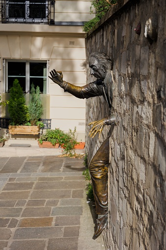 Paris, France – October 25, 2022: The Le Passe-Muraille unusual sculpture of a man embedded in a wall