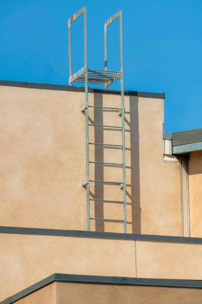 istock Vertical shot of an exit ladder of a building under a clear blue sky 1464064518