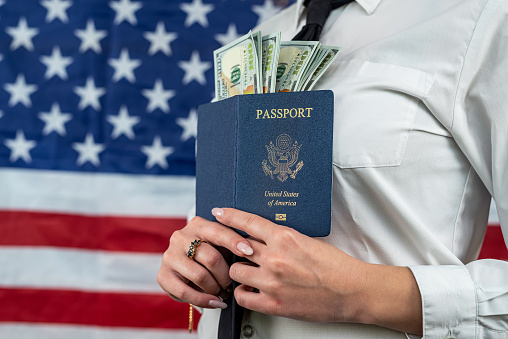 Beautiful woman holding a passport with money dollars for traveling abroad. the concept of traveling abroad. tourist concept