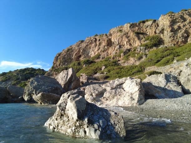 Empty beautiful beach with rocks and mountains in background