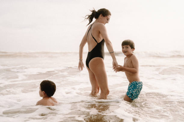 istock Mother playing with children at the beach 1464067544