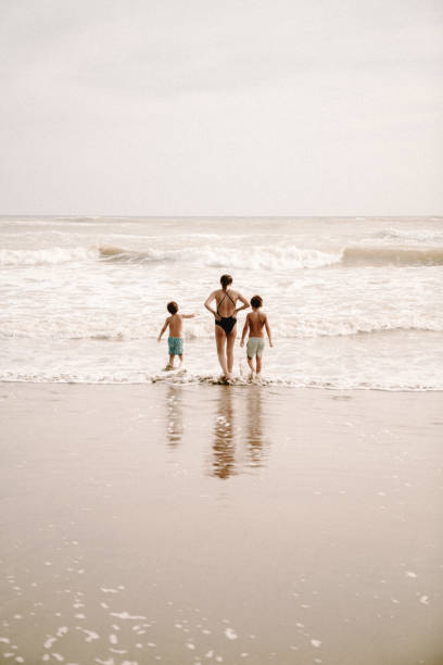 istock Mother playing with children at the beach 1464067638