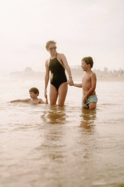 istock Mother playing with children at the beach 1464067817