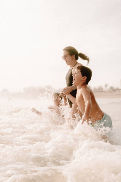 istock Mother playing with children at the beach 1464068081