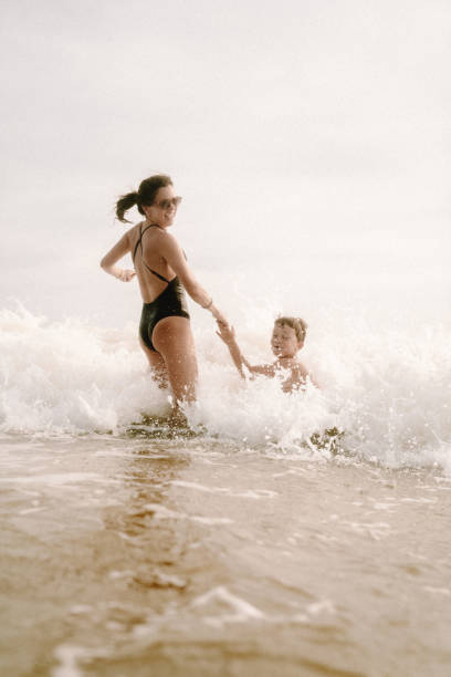 istock Mother playing with children at the beach 1464068092