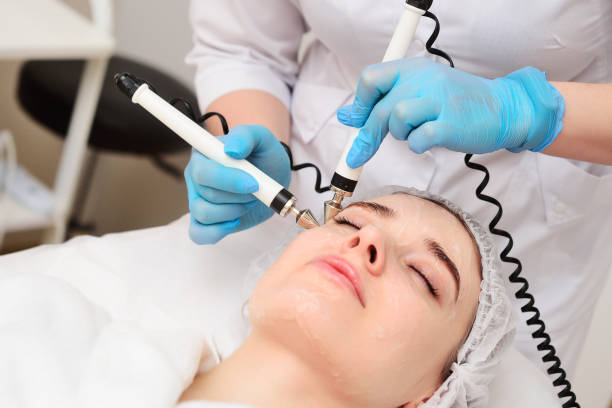 istock cosmetologist conducts microcurrent facial therapy for a young woman using a device in a beauty salon. Hardware cosmetology, skin care, rejuvenation, regeneration. 1464073490