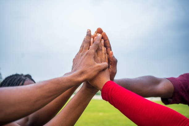 istock Teamwork concept with different skin color touching hands standing outside 1464075308