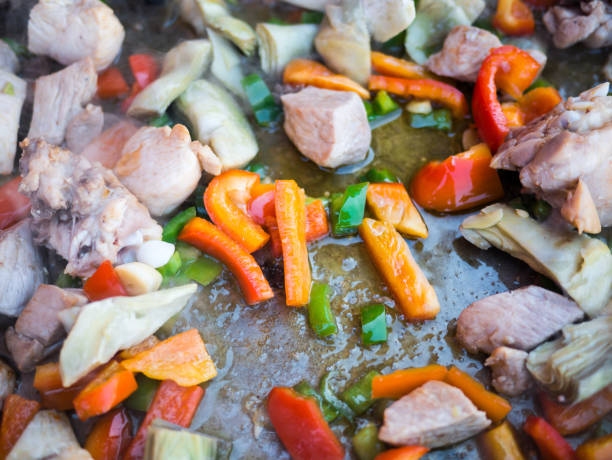 Process of cooking paella with chicken and vegetables