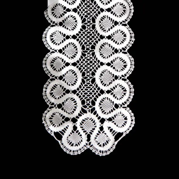 Photo of White handmade lace on black background