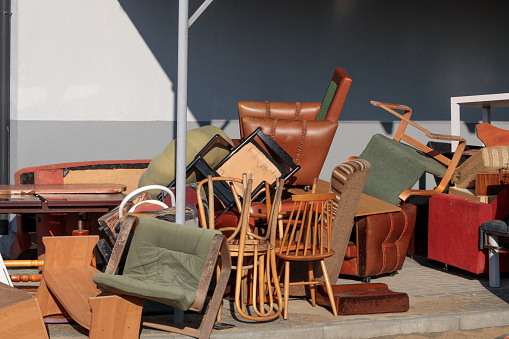 Old, damaged furniture at landfill close to brick house. Big problem.