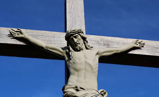 obere hälfte der lebensgroßen betonkreuzigung im freien vor blauem himmel - stone cross stock-fotos und bilder