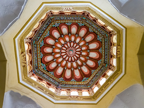 The ornately carved, colorful ceiling of the ancient Tirumalai Nayak Palace in the city of Madurai.