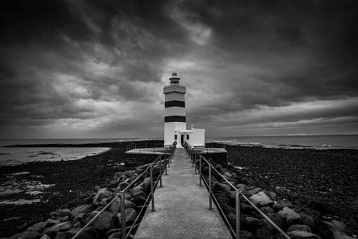 A dramatic view of an old lighthouse Gardur under a cloudy sky in Iceland