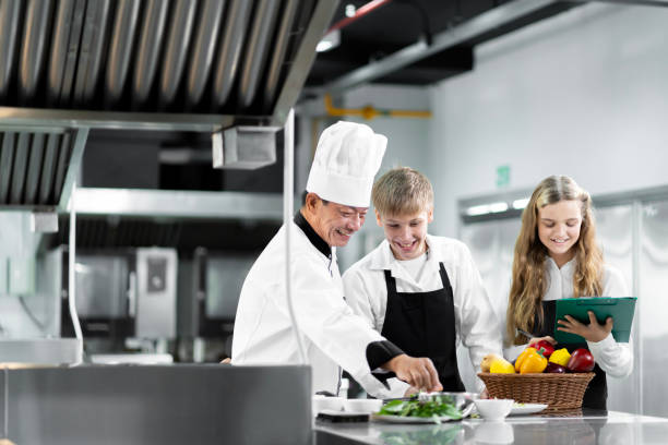 students are learning to cook in a culinary institute with a standard kitchen and complete equipment. and have a professional chef as a trainer. - chef trainee cooking teenager imagens e fotografias de stock