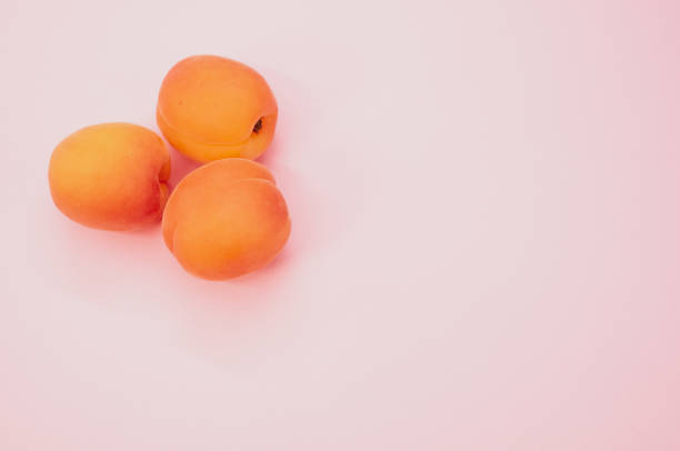 istock High angle shot of fresh three apricots isolated on pink background 1464082797