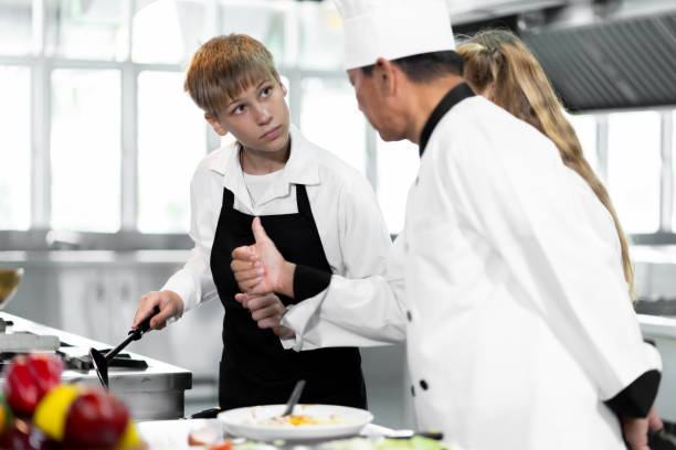 학생들은 표준 주방과 완벽한 장비를 갖춘 요리 연구소에서 요리하는 법을 배우고 있습니다. 그리고 전문 요리사를 트레이너로 삼으십시오. - chef trainee cooking teenager 뉴스 사진 이미지