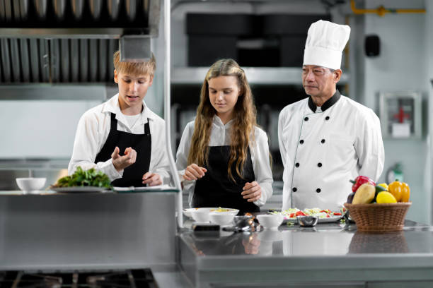 istock Students are learning to cook in a culinary institute with a standard kitchen and complete equipment. And have a professional chef as a trainer. 1464083496