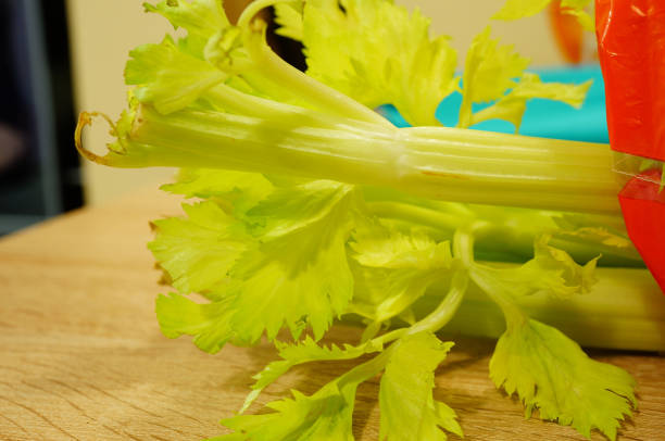 istock Closeup of fresh Celery stalks on a wooden board 1464090902
