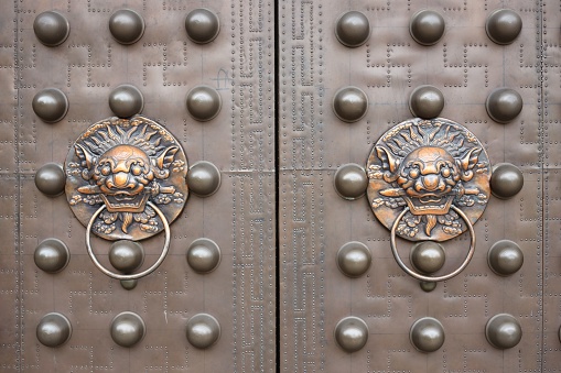 Asian Lion Door Knockers on Red Gate