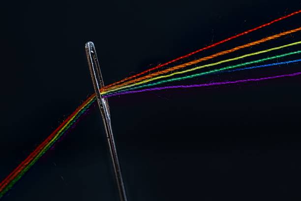 istock Closeup shot of a needle with colorful threads on a black background 1464097553
