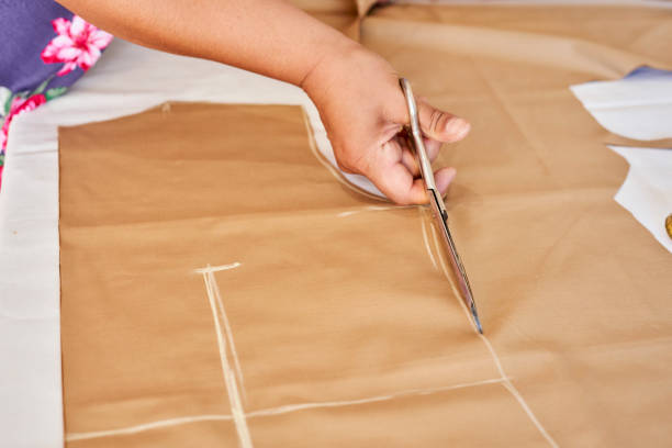 istock Dressmaker cutting cloth with scissors in a tailor studio 1464099024