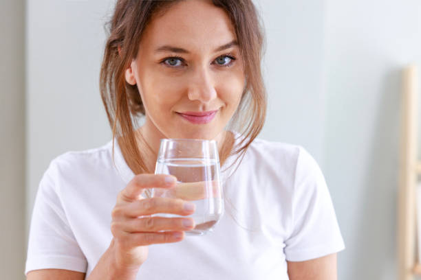 istock Woman drinking water at home 1464099040