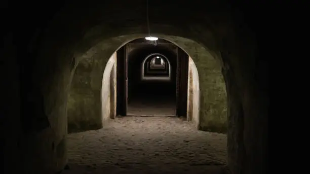 First person view walking through the military tunnel in the dungeon. Defensive structure, casemates. Bomb shelter during the war. Copy space for text. Catacombs