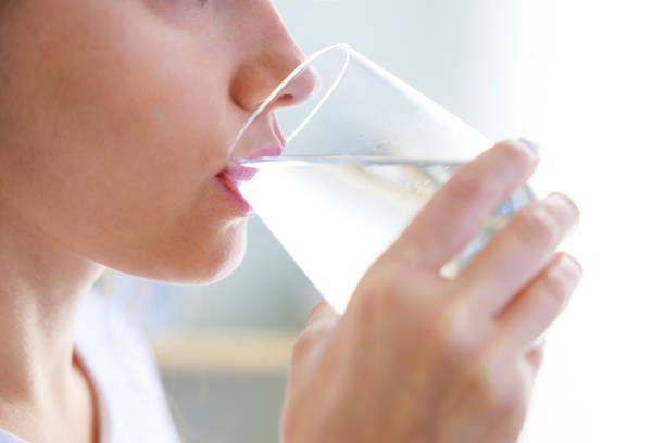 istock Woman drinking water at home 1464100476