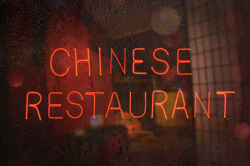 A closeup shot of a vintage Chinese Restaurant sign on a wet window