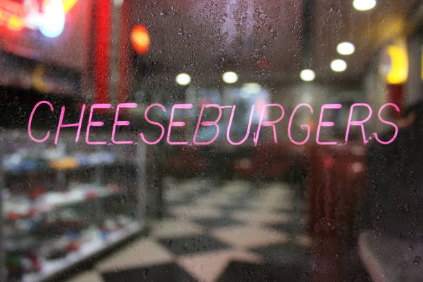 istock Neon sign 'cheeseburgers' on a rainy window 1464100698