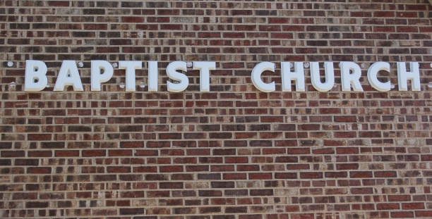 istock Brick wall with a baptist church sign 1464100704