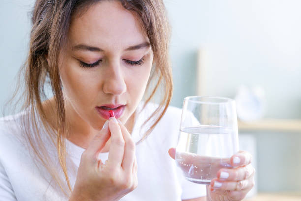 istock Young woman taking medication at home 1464100846