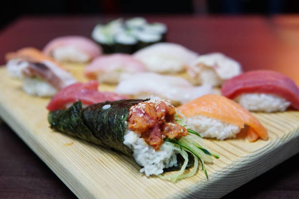 A delicious temaki roll on the board with nigiri and sushi rolls