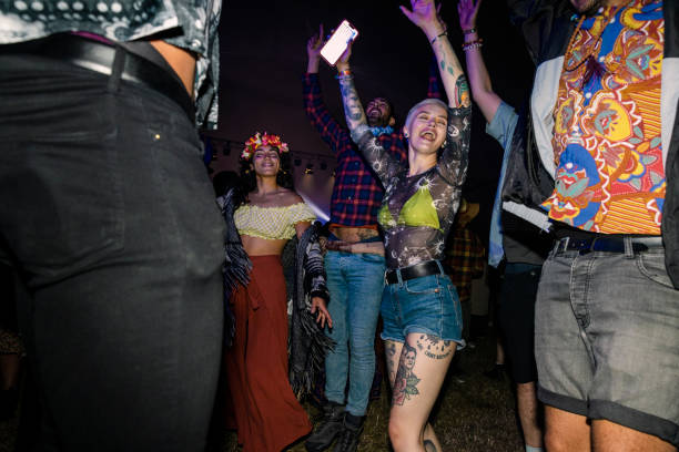 A small group of friends at a festival all dancing together and having a good time. Everyone is happy and smiling and sharing positive energy.