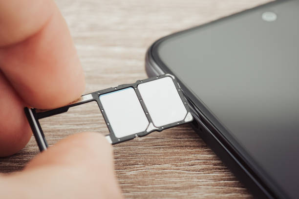istock Close up of men hand inserting different sim cards in smartphone, toned image 1464103680