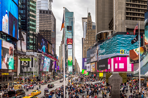 New York, USA - April 24, 2022: Times Square with tourists. Iconified as The Crossroads of the World it's the brightly illuminated hub of the Broadway Theater District