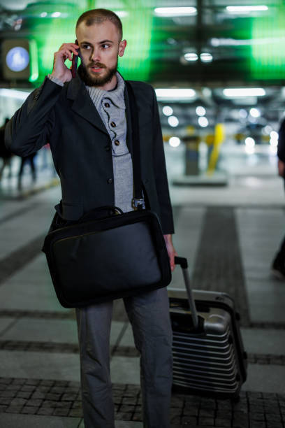 istock A young businessman with a briefcase is exiting an airport and talking using a phone. 1464112932