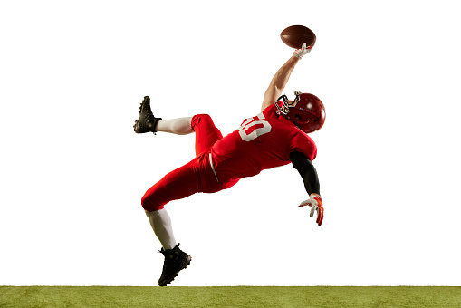 Professional american football player in sports uniform and protective helmet in action isolated over white background. Concept of active life, team game, energy, sport, competition. Copy space for ad