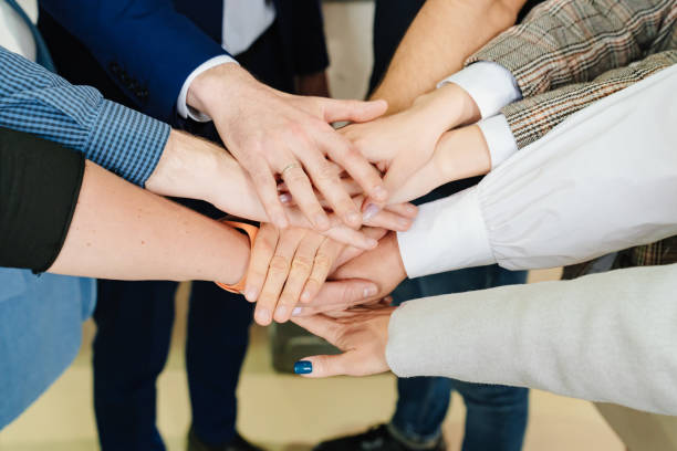 istock women's and men's hands folded together. the concept of teamwork and support. 1464113157