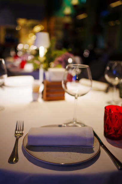 istock a table with a white tablecloth, glasses, crockery and decor in dark restaurant 1464113962