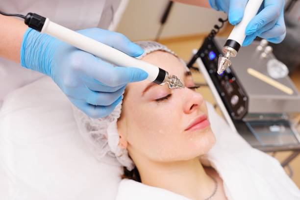 istock cosmetologist conducts microcurrent facial therapy for a young woman using a device in a beauty salon. Hardware cosmetology, skin care, rejuvenation, regeneration. 1464115791