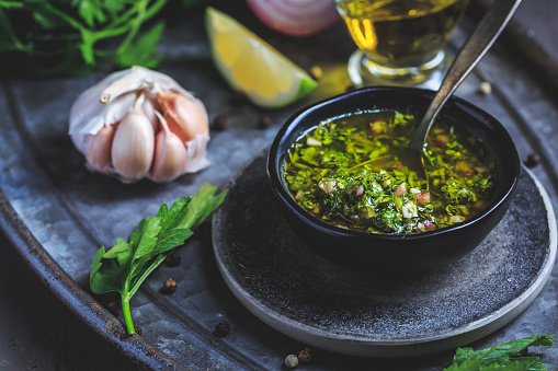 Chimichurri verde - traditional Argentine condiment, made from finely chopped parsley, minced garlic, olive oil, oregano, and wine vinegar