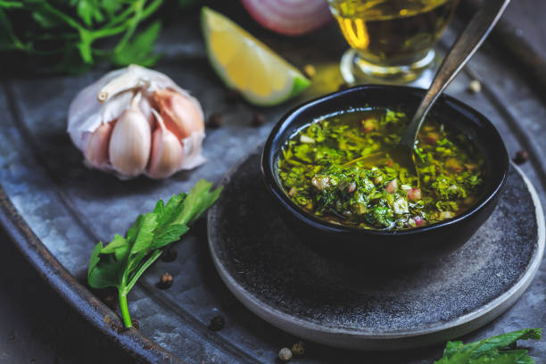 Chimichurri verde - traditional Argentine condiment Chimichurri verde - traditional Argentine condiment, made from finely chopped parsley, minced garlic, olive oil, oregano, and wine vinegar chimichurri stock pictures, royalty-free photos & images