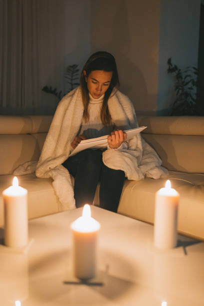 istock A young woman reads a book by candlelight 1464116742