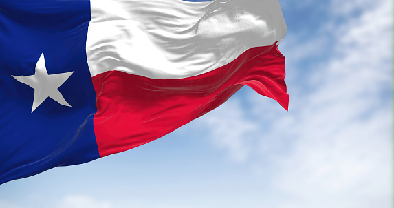 The Texas state flag fluttering in the wind on a sunny day. Texas flag is called Lone Star Flag. Fluttering textile. Realistic 3d illustration render