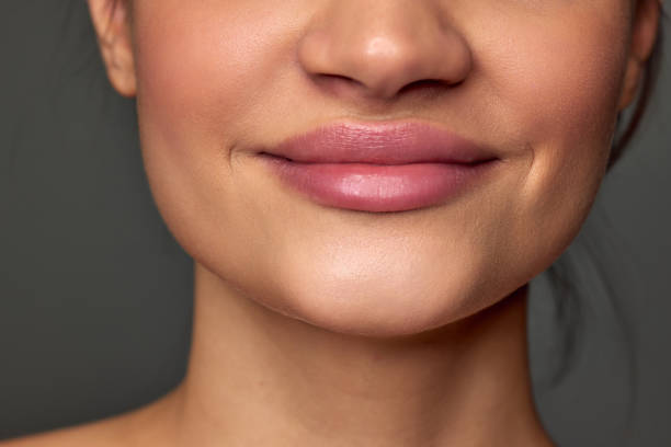 istock Cropped image of female face, lips, nose, chin over grey studio background. Lip augmentation, face lifting, plastic surgery. Concept of natural beauty, skin care, cosmetology 1464119344