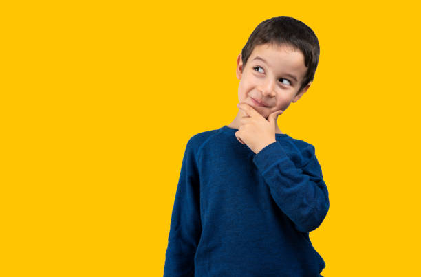 istock rogue little boy looking askance over yellow background 1464120284