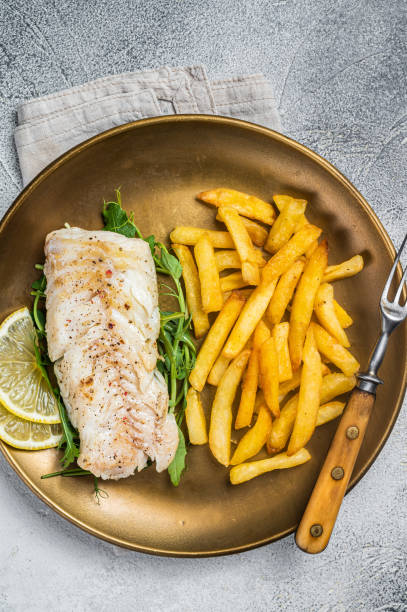istock Fried cod fish fillet served with french fries. White background. Top view 1464121167