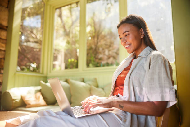 Young woman smiling while working on a laptop at home